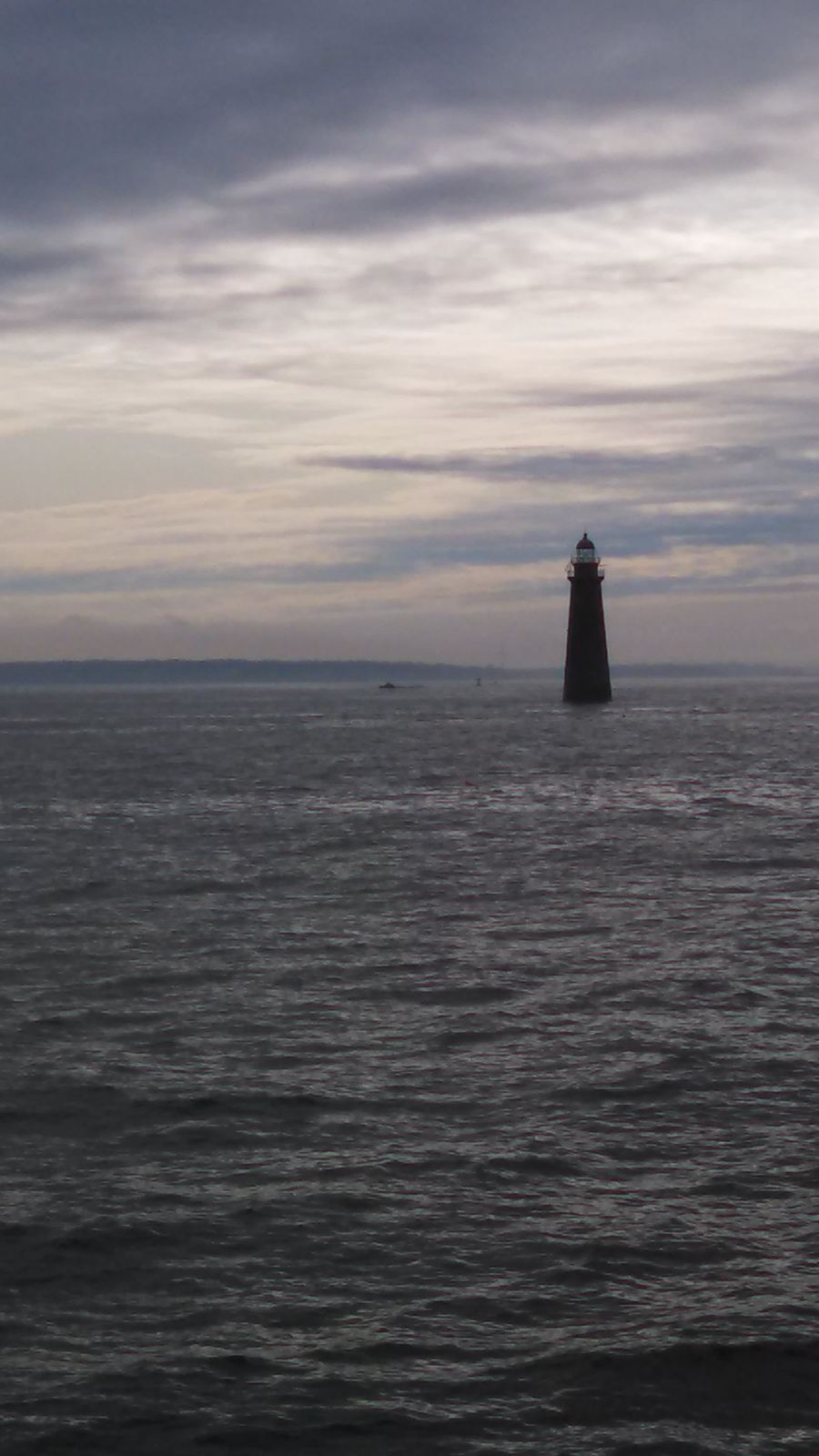 Minot's Ledge Light seen across the water under an evening sky